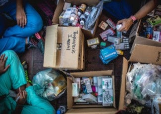 healthcare workers sort through boxes of medicine